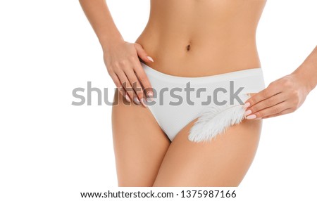woman touching with feather her genitals wearing panties , showing smooth skin after epilated or depilating bikini area. Royalty-Free Stock Photo #1375987166