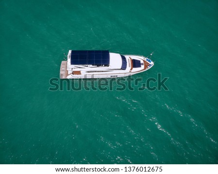 Aerial photo of an isolated luxury white  yacht with blue roof design in the sea