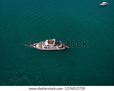Aerial picture of an isolated yacht with brown wooden design in the sea