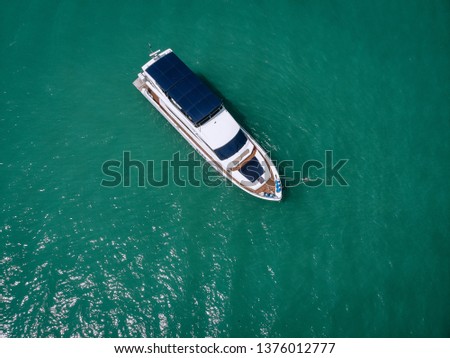 Aerial photo of an isolated luxury white  yacht with blue roof design in the sea