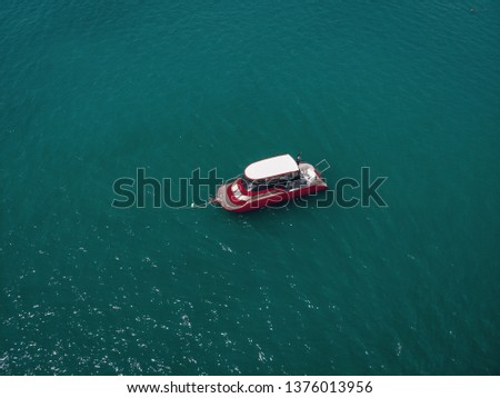 Aerial picture of an isolated yacht with red design in the sea
