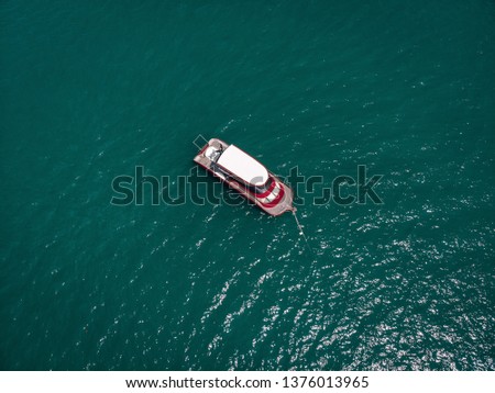 Aerial picture of an isolated yacht with red design in the sea