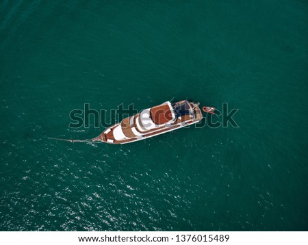 Aerial picture of an isolated yacht with brown wooden design in the sea