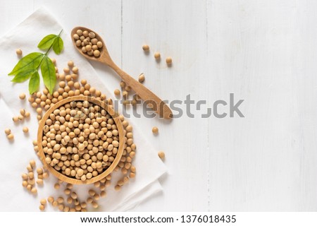 top view of soybean or soya bean in a bowl on white wooden background Royalty-Free Stock Photo #1376018435