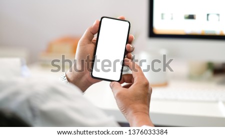 Businessman hand holding mobile smartphone in office