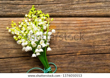 bunch of lily of the valley flowers on old weathered wooden table, directly above