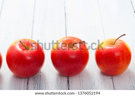 apple fruits in a row, white wooden table background