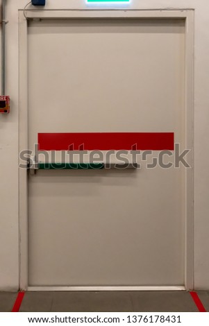 Building emergency exit door with fire alarm switch on wall