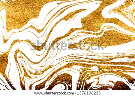 Golden swirl, artistic design. Suminagashi – the ancient art of Japanese marbling. Paper marbling is a method of aqueous surface design. White paper and gold texture.  Royalty-Free Stock Photo #1376196233