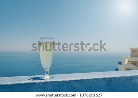 Glass of white dry wine over seaside background, summertime.