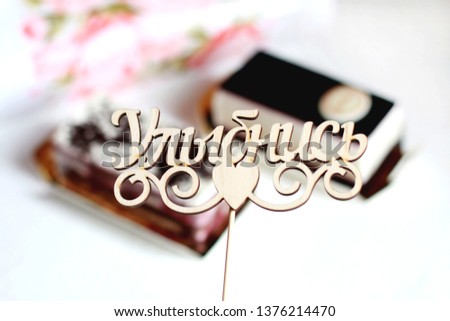 The Russian inscription which is translated into English as "Smile" against the background of cakes