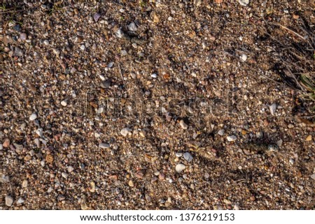 texture of small stones of rubble and sand, road top view
