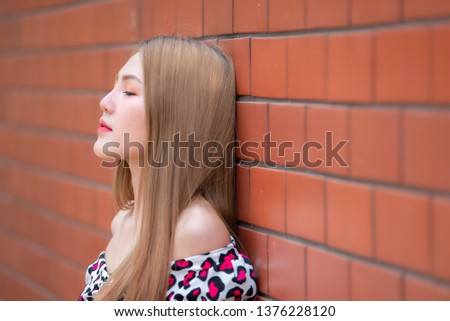 Portrait of beautiful asian chic girl wear black dress pose for take a picture on brick wall,Lifestyle of teen thailand people,Modern woman happy concept,Korea style