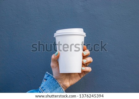 Mockup of female hand holding a Coffee paper cup isolated on dark background Royalty-Free Stock Photo #1376245394