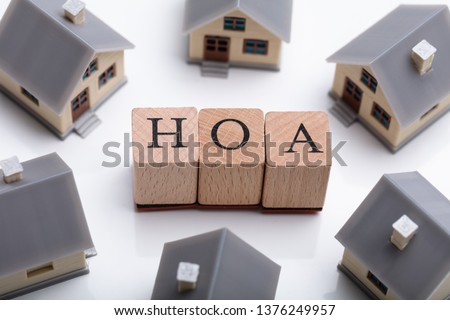 House Models Around HOA Cubic Blocks Over Reflective Desk Royalty-Free Stock Photo #1376249957