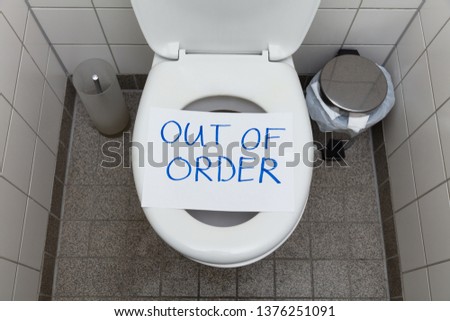 Written Text Out Of Order Message On Paper Over Toilet Bowl In Bathroom
