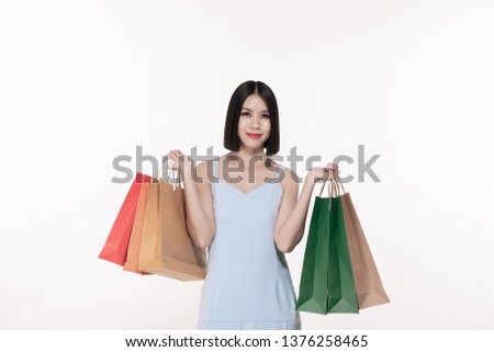 Shopping concept. Beautiful girl is carrying a bag on a white background. Asian girls are buying things happily.