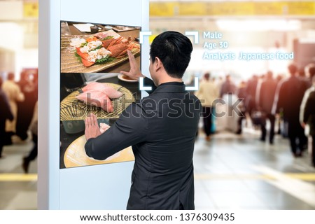 Intelligent Digital Signage , Augmented reality marketing and face recognition concept. Interactive artificial intelligence digital advertisement sushi Japanese restaurant in subway or sky train.