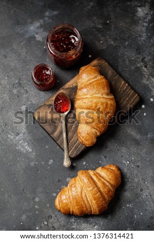 French croissant. Freshly baked croissants with jam on dark stone background. Tasty croissants with copy space Royalty-Free Stock Photo #1376314421