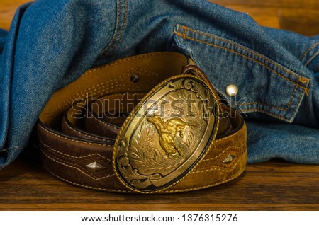 Vintage Western Belt Buckle on Rustic Wood with Denim Shirt