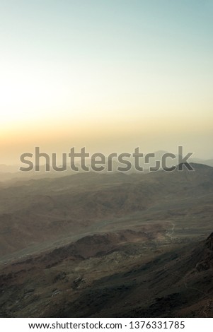 Middle East or Africa, picturesque bare mountain range and a large sandy valley desert landscapes landscape photography. Vertical frame