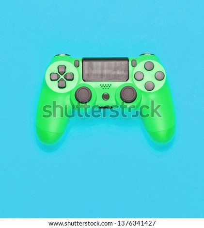 Modern green gamepad (joystick) on blue background. Top view

