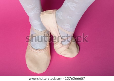 little ballerina's legs in pointe on a pink background. ballet position
