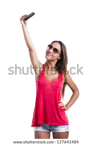 Beautiful woman taking pictures with cell phone, isolated over white background