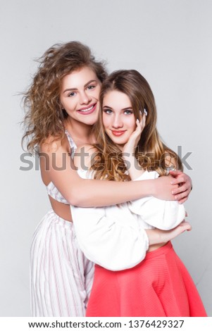 Cutte girls in colorful casual clothes hugging and smilling together!