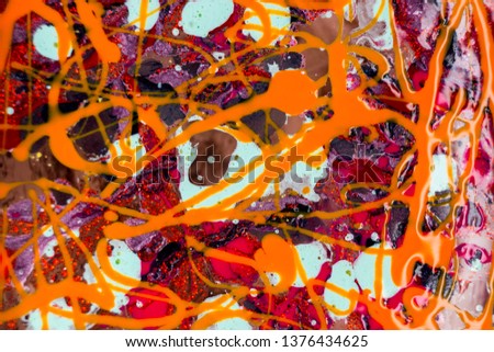 Nail Polish color on the water. Abstract pouring varnish on the water. Purple, red, orange.