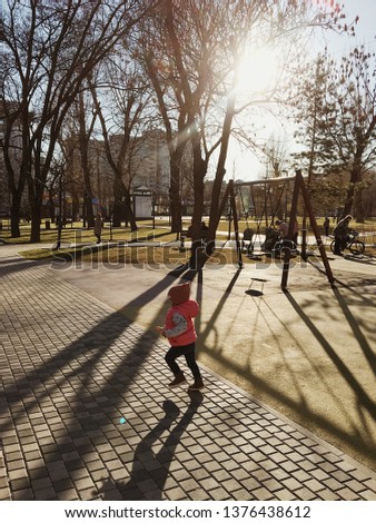 little girl runs in a park in the sunshine at sunset in Moscow