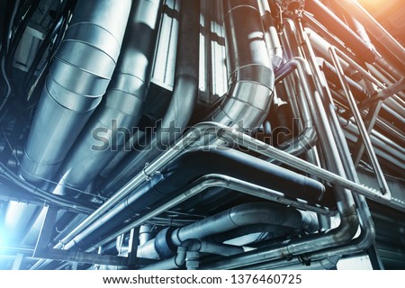 Industrial steel pipes or tubes of air ventilation system as abstract industry equipment background in blue tones Royalty-Free Stock Photo #1376460725