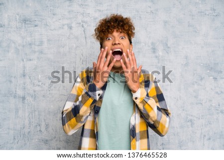 Fashion african american over grunge wall with surprise facial expression