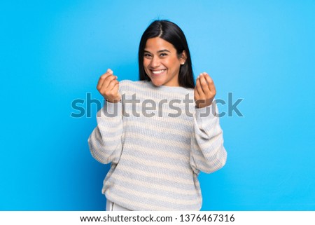 Young Colombian girl with sweater making money gesture