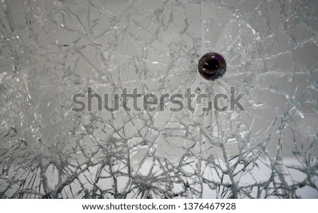 Smashed glass with bullet stuck in cracks with copy space 