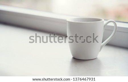 White blank Mug on windowsill  at morning