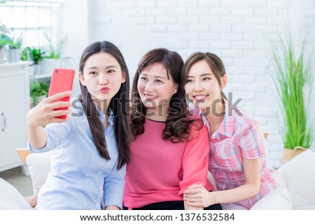 Daughters and mom take selfie together happily
