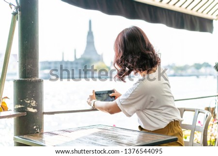 Asian woman traveler taking a photo in cafe restaurant