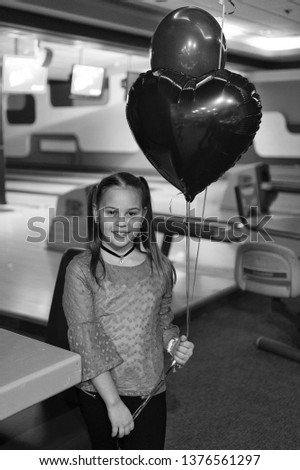 Girl with balloons celebrate birthday in bowling club. Birthday party at bowling. Ideas how to celebrate birthday for teens. Girl cute smiling child hold bunch balloons lighted with blue light.