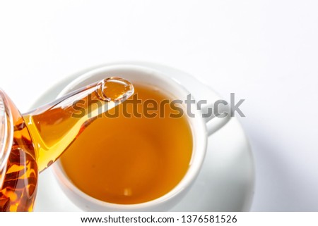 From a glass teapot poured tea into a Cup. Teapot with exotic green tea. Tea ceremony