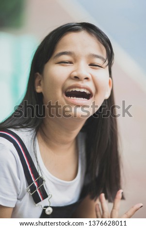 close up face of asian teenager laughing with happiness emotion