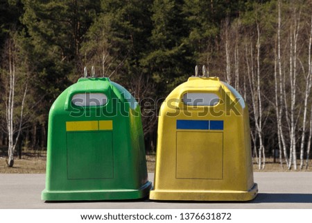 Two garbage containers on the background of nature. The concept of respect for nature and recycling.