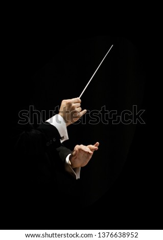 Hands of conductor on a black background Royalty-Free Stock Photo #1376638952