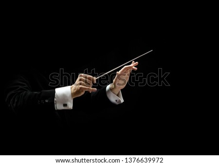 Hands of conductor on a black background Royalty-Free Stock Photo #1376639972