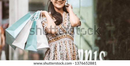 Lifestyle shopping concept, Young happy smiling woman with paper bag and dress in shopping street at evening, vintage style