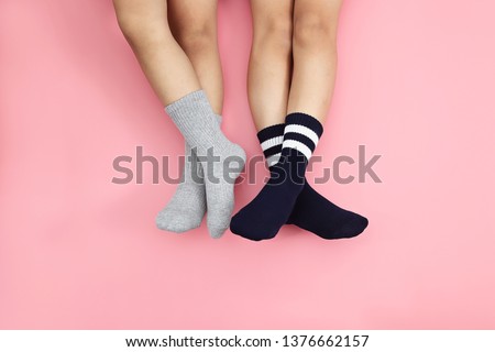 Kids wearing cute grey and black socks on pink background. Minimalism fashionable winter set.