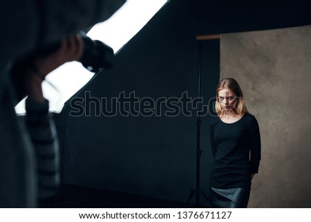 Woman in dark clothes posing indoors for photographers                        