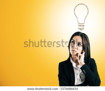 Portrait of attractive young european businesswoman with creative hand gesture lightbulb on orange background. Communication, community, inspire, idea and innovation concept