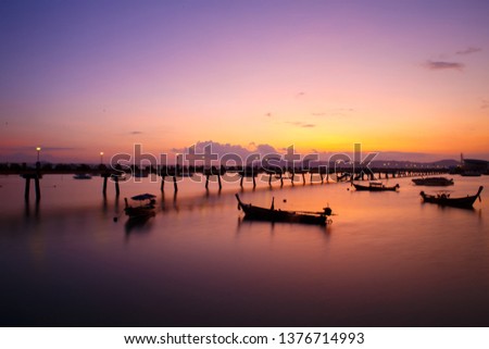Beautiful sunrise and landscapes of the Wooden Bridge Pier with boats during the sunrise summer travel in Phuket, Thailand. Nice view and beautiful background.