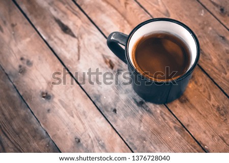 Cup of coffee on wooden plank table background
